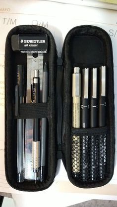 an open black case with pens and pencils in it