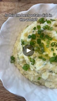 mashed potatoes with green onions in a white bowl on a wooden table, and the words is this the best potato dish in the world?