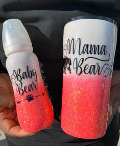 two water bottles with the words mama bear and baby bear painted on them are being held in someone's hands