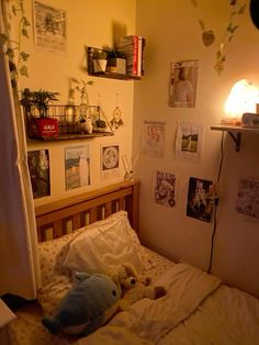 there is a stuffed animal on the bed in this room with many pictures and plants