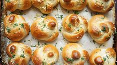 freshly baked rolls with cheese and herbs on a baking sheet, ready to go into the oven