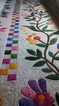 a quilted table runner with colorful flowers on it