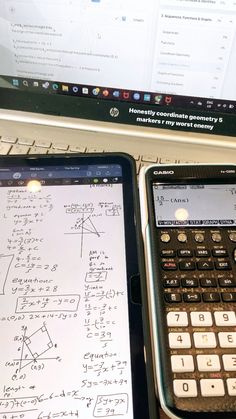 two calculators sitting next to each other on top of a laptop computer screen