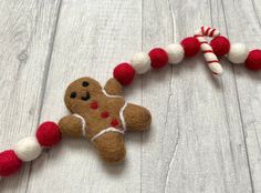 a brown and white gingerbread christmas ornament next to a red and white candy cane