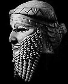 a black and white photo of an ancient statue with intricately carved headdress