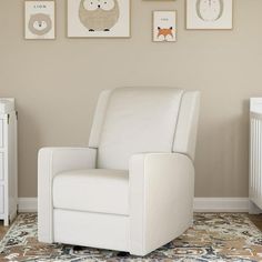 a baby's room with pictures on the wall and a white reclining chair