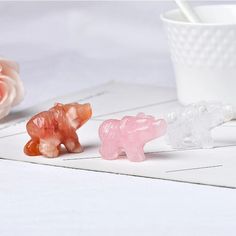 three gummy bears sitting on top of a table next to a white coffee cup