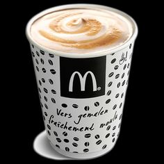 a close up of a cup of coffee on a black background with the logo mcdonald's