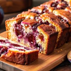 sliced loaf of fruit bread sitting on top of a wooden cutting board