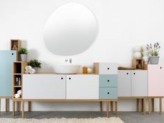 a white sink sitting on top of a wooden dresser next to a mirror and shelves