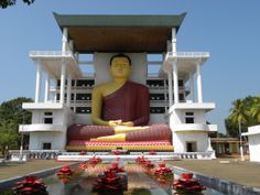 a large buddha statue sitting in front of a building