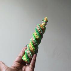 a hand is holding a toy made out of beads