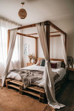 a canopy bed made out of pallet wood with white drapes on the top