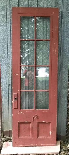 LOCAL PICK UP ONLY Nice vintage single tall exterior wood storm door. The door only includes the glass storm door insert. The insert has 8 individual panes of glass. The bottom 2 panes are shorter in height. The glass is complete and in good undamaged condition. Door will need additional cleaning as the glass is dirty.  The glazing is mostly crumbled loose and will need to be re glazed. This is a right swing storm door.  The door has a flat 2 panel bottom. The wood is unknown. The door is in a crusty thick brick red color with a chipped flaky green over creamy tan backside.     The door is salvaged and will have small chips, dings, nail holes and scuffs.   The door is solid with tight joints. The insert fits firmly and is held in with turn tabs.  The insert mounts may not be original. The Glass Storm Door, Wood Storm Doors, Glass Storm Doors, Brick Red Color, Address Numbers, Storm Door, Nail Holes, Exterior Wood, Brick Red