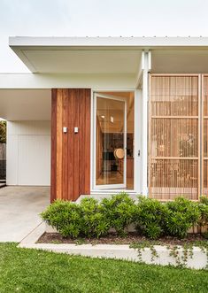 a small white house with wooden doors and windows