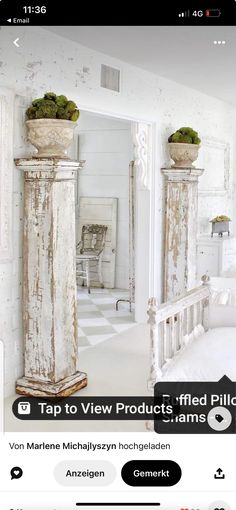 an image of a room with white walls and furniture on the floor, including two tall pillars