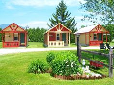 two small cabins are in the grass next to each other