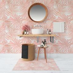 a bathroom with pink and white wallpaper, a round mirror above the sink and two stools