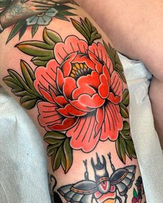 a woman's arm with tattoos and flowers on it