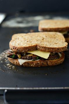 two sandwiches sitting on top of a pan covered in cheese