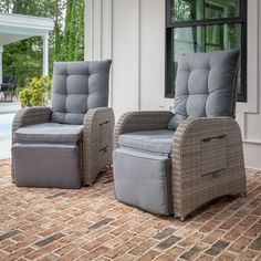 two chairs sitting next to each other in front of a house with a swimming pool