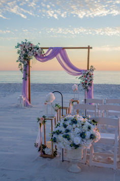 an outdoor wedding setup on the beach at sunset