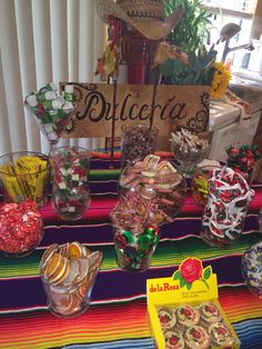 a table topped with lots of candy and candies next to a sign that says dolceria