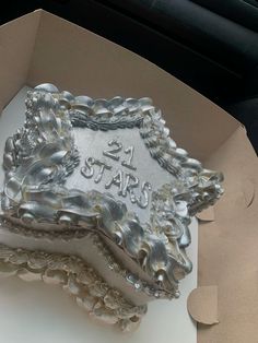 there is a cake in the box that says 21st birthday and it's made out of silver foil