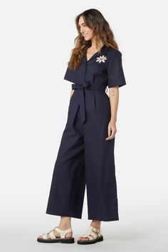 Daisy embroidered jumpsuit - a classic button through jumpsuit, with a sweet embroidered daisy - short sleeves - button through front - pointed open collar style - wide cut leg - crafted from textured linen cotton blend fabric - available in navy Product Code: PGFW326 Summer Short Sleeve Jumpsuits And Rompers With Button Closure, Relaxed Fit Cotton Denim Jumpsuit With Short Sleeves, Relaxed Fit Cotton Denim Jumpsuit, Short Sleeve Denim Jumpsuit For Work, Cotton Denim Jumpsuit With Short Sleeves, Summer Daywear Short Sleeve Jumpsuits And Rompers, Summer Short Sleeve Jumpsuits And Rompers For Daywear, Summer Daywear Jumpsuits And Rompers With Short Sleeves, Relaxed Fit Cotton Collared Jumpsuit