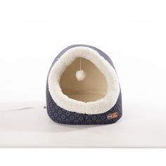 a cat bed with an apple hanging from it's side on a white background