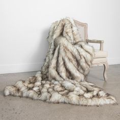 a pile of yarn sitting on top of a floor next to a white chair and wall