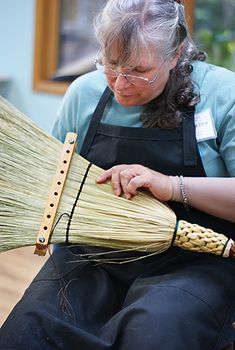 a woman sitting down with a broom in her hand