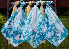 three blue and white towels hanging on a fence