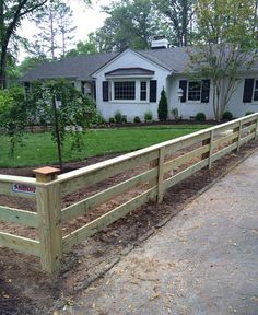 a wooden fence in front of a white house