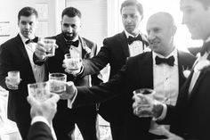 a group of men in tuxedos are toasting with beer glasses on their hands