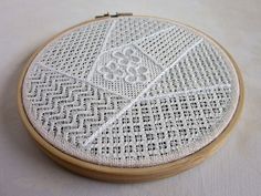 a close up of a embroidery on a wooden hoop