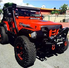 an orange jeep is parked on the street