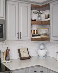 a kitchen with white cabinets and gray counter tops