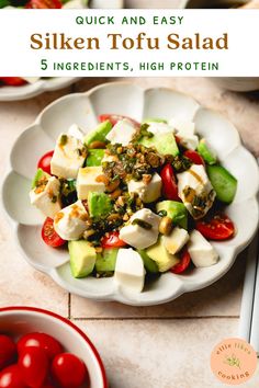 a white bowl filled with sliced vegetables on top of a table next to tomatoes and cucumbers