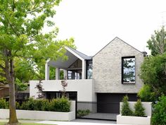 a modern house in the suburbs with trees and bushes