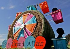 there is a sign that says it's a grand affair in front of a large hay ball