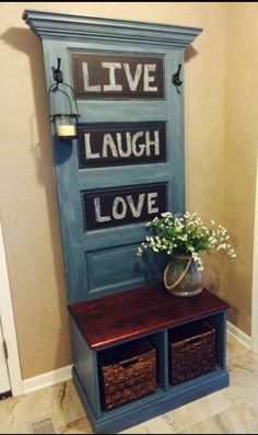 a blue door with some baskets on top of it and flowers in a vase next to it