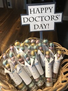 a basket filled with lots of different types of candies in small bottles and tags