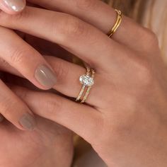 a woman's hands with two gold rings and a diamond ring