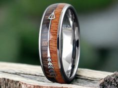 a wooden ring with an arrow inlayed to the side on top of a piece of wood