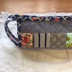 a quilted purse sitting on top of a white doily next to a wooden table