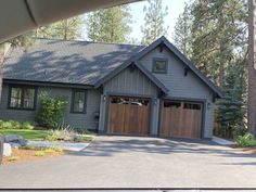 a car is parked in front of a house with two garage doors on each side