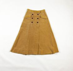 "-SO SO PRETTY!  -1950s heavy weight khaki corduroy circle skirt  -double breasted jacket button details  -waist measures 25 inches  -has small pockets at hips  -good vintage condition with the exception of some pressing of the corduroy here and there, there is also a small pen mark on the back right hip of the skirt  -tag says \"John Miller of Bryn Mawr\" MEASUREMENTS waist: 12.5 inches flat  hips: 20 inches flat  length: 30 inches" Vintage Fall Skirt With Pockets, Vintage Skirt For Fall, Vintage Fall Skirt With Buttons, Vintage Brown Skirt With Buttons, Retro Brown Skirt With Button Closure, Vintage Winter Skirt With Buttons, Retro Fall Skirt With Buttons, Retro Fitted Skirt With Buttons, Vintage Brown Bottoms With Buttons