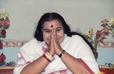 a woman sitting at a table with her hands together