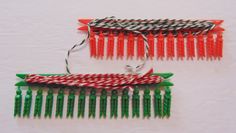 two plastic combs with red and green handles on white surface, one has a string attached to it